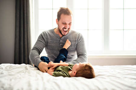 A Father and son on bed playing Portrait of happy child