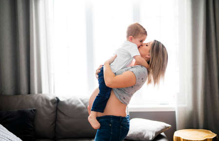 A mother with his child son on the living room close to the window
