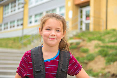 A nice Portrait of cute girl with backpack at school