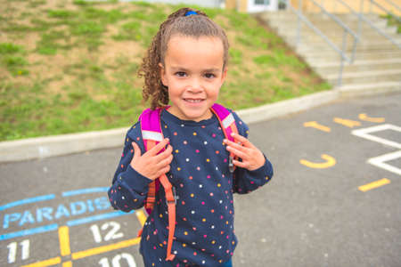 A nice Portrait of cute hispanic girl with backpack at school