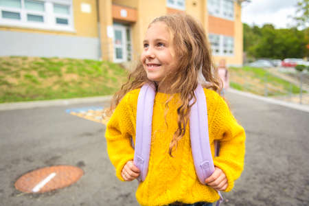 Portrait of cute girl with backpack at school