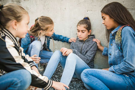 girl problem at school, sitting and consoling child each otherの写真素材