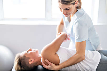 A Modern rehabilitation physiotherapy worker with woman client