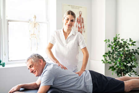A Modern rehabilitation physiotherapy worker with senior client