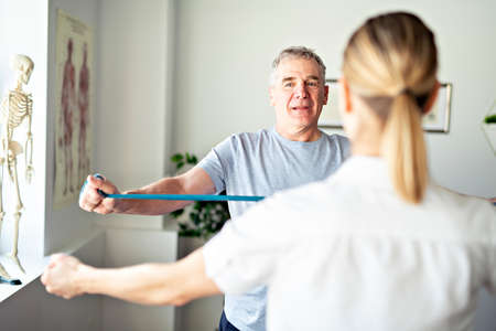 A Modern rehabilitation physiotherapy worker with senior clientの写真素材