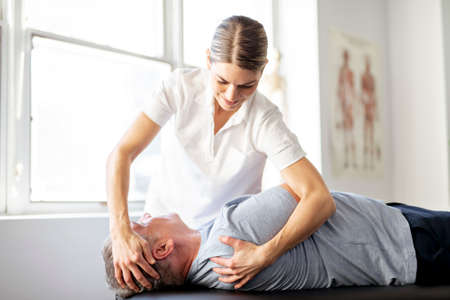 A Modern rehabilitation physiotherapy worker with senior clientの写真素材