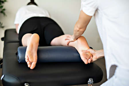 A Modern rehabilitation physiotherapy woman worker with clientの写真素材