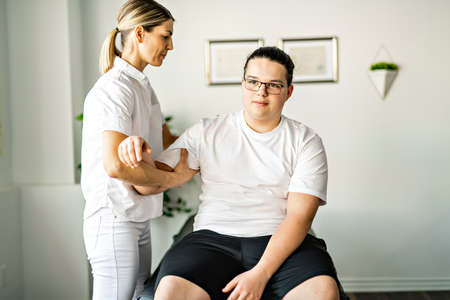 A Modern rehabilitation physiotherapy woman worker with clientの写真素材