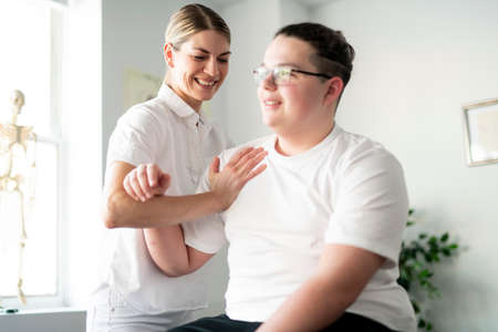 A Modern rehabilitation physiotherapy woman worker with clientの写真素材
