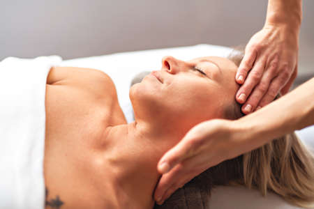 A Woman enjoying spa treatment at salon with masseur workerの写真素材