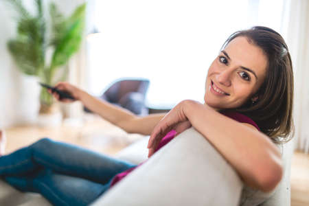 Brunette having good time on the living room watching tv