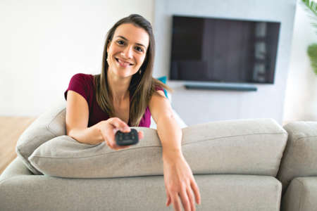 Brunette having good time on the living room watching tv