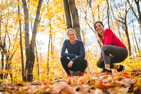 Two running woman jogging in autumn natureの写真素材