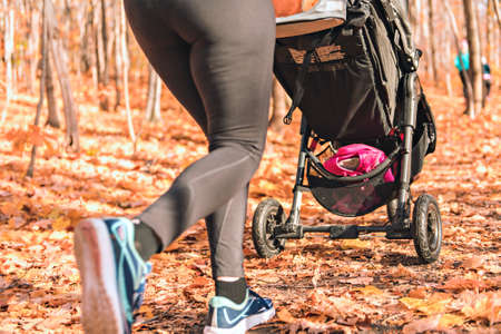 Stroller woman running in an autumn park they run a race or train in a healthy outdoors lifestyle conceptの写真素材