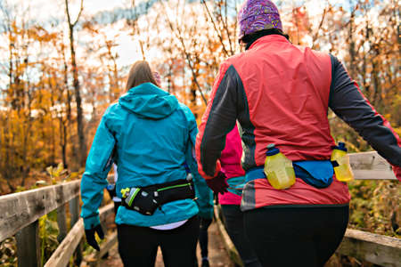 woman group out running together in an autumn park they run a race or train in a healthy outdoors...