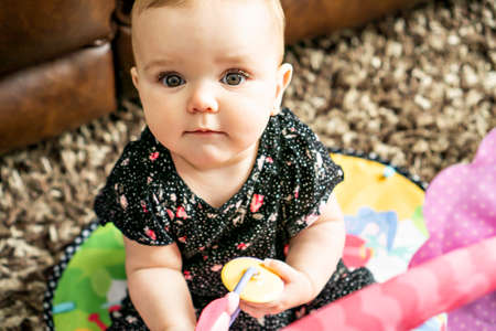 A cute baby playing with colorful toy at home