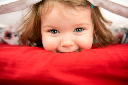 A child girl having fun on bedroomの写真素材