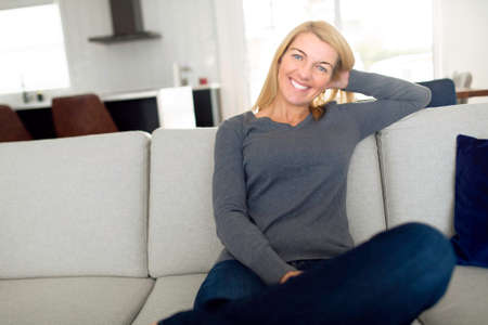 Relaxed woman enjoying rest on comfortable sofa, calm attractive girl relaxing on couch