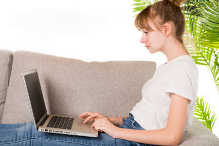Happy woman relaxing on cozy sofa with laptop in living room at home