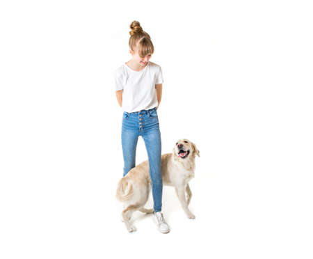 Nice teen woman and her beautiful Golden Retriever dog over white background