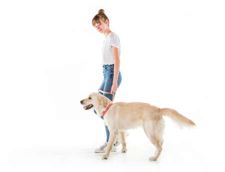 Nice teen woman and her beautiful Golden Retriever dog over white background