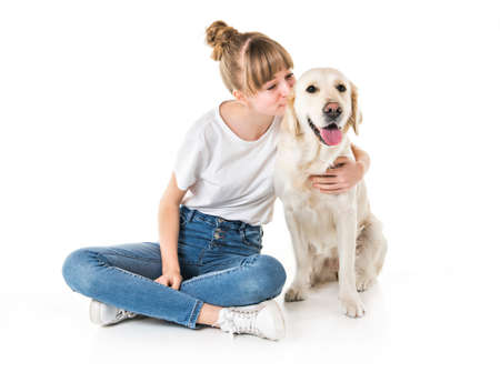 Nice teen woman and her beautiful Golden Retriever dog over white background