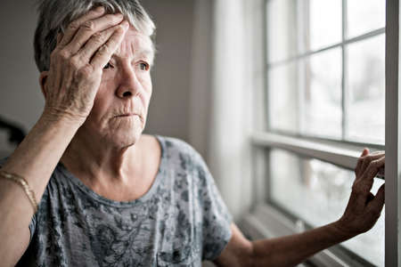 A sad lonely 70 years old senior in is apartmentの写真素材