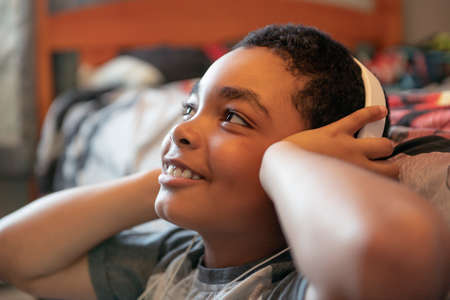 A Portrait of a sweet young boy listening to music on headphones