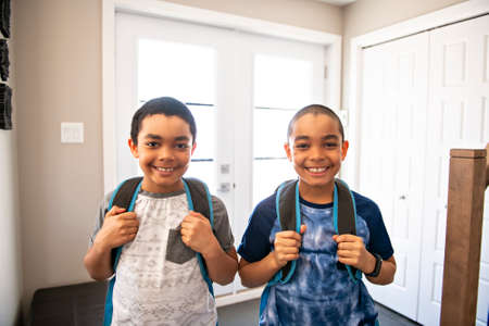 A child boy coming home passing through the door after school