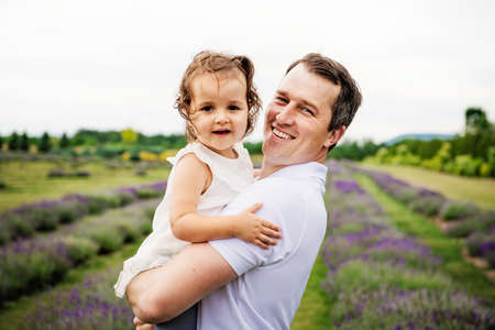 Happy family father and daughter having fun in lavender fieldの写真素材