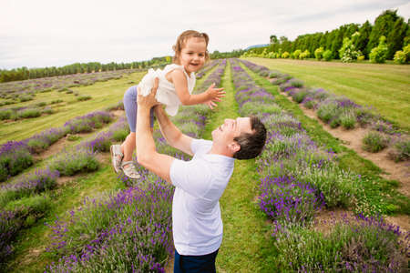 Happy family father and daughter having fun in lavender fieldの写真素材
