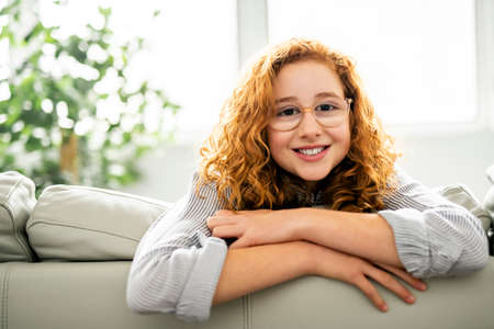 child watching tv on the sofa at home alone