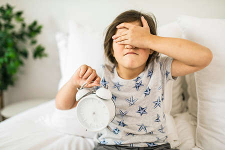 Portrait of depress girl sleeping and holding hand on alarm clock