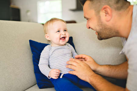 Father And Son Playing On Sofa Together