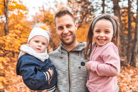 A portrait of a young family in the autumn park