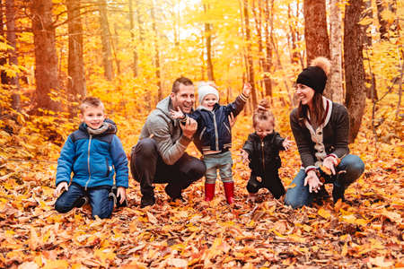 A portrait of a young family in the autumn parkの写真素材
