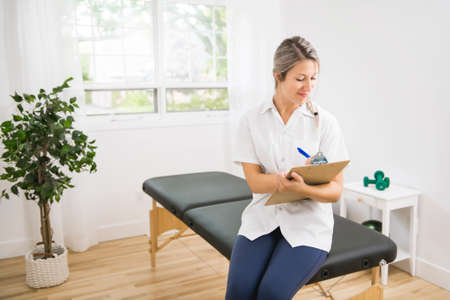 Young physiotherapist with clipboard in rehabilitation center