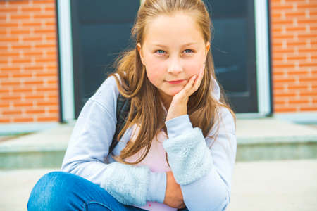 A student school girl on the playground on the first day of class