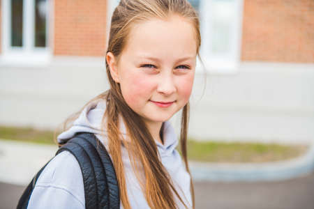 A student school girl on the playground on the first day of class