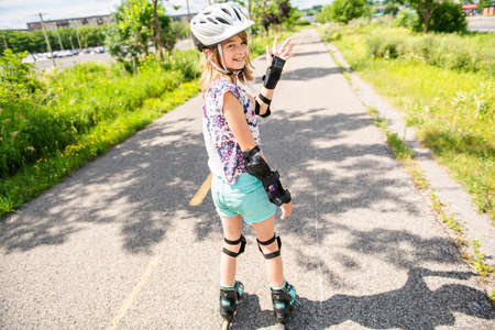 Child on inline skates. Little girl skating on sunny summer day.の写真素材