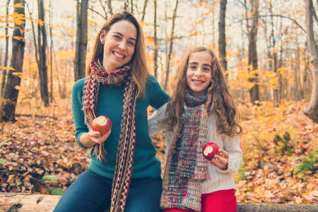 A portrait of a mother with child in the autumn parkの写真素材