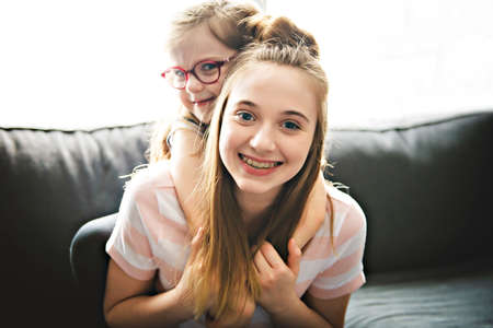 Two sister having fun on the sofaの写真素材