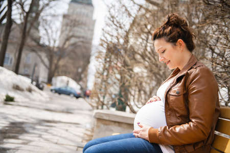 Pregnant girl outside sit on a benchの写真素材