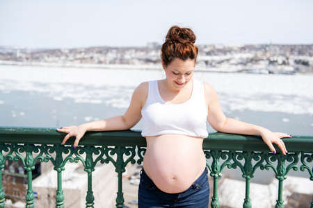 Pregnant girl outside on a city backgroundの写真素材