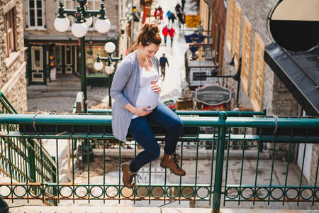 Pregnant girl outside on a city background