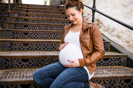 Pregnant girl outside on a rust stair