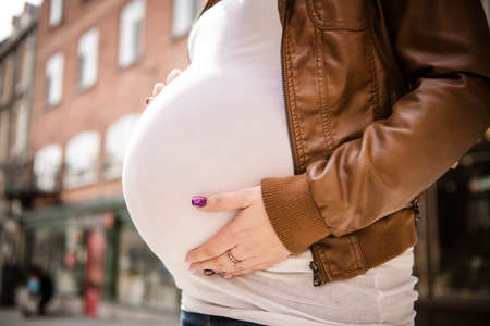 Pregnant girl outside on a city background