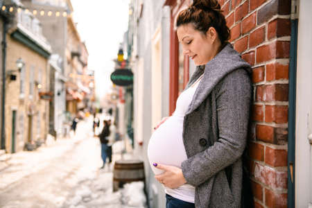 Pregnant girl outside on a city backgroundの写真素材
