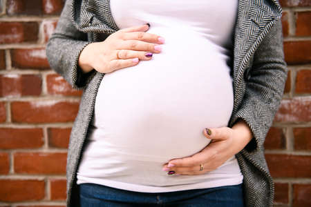 Pregnant girl outside on a city background