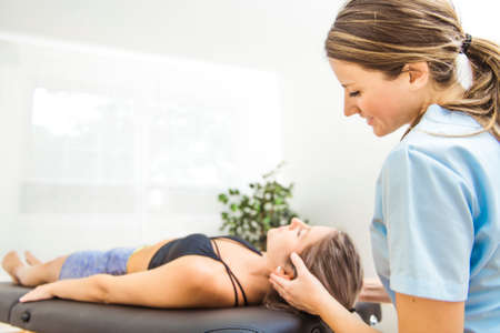 A Modern rehabilitation physiotherapist at work with clientの写真素材